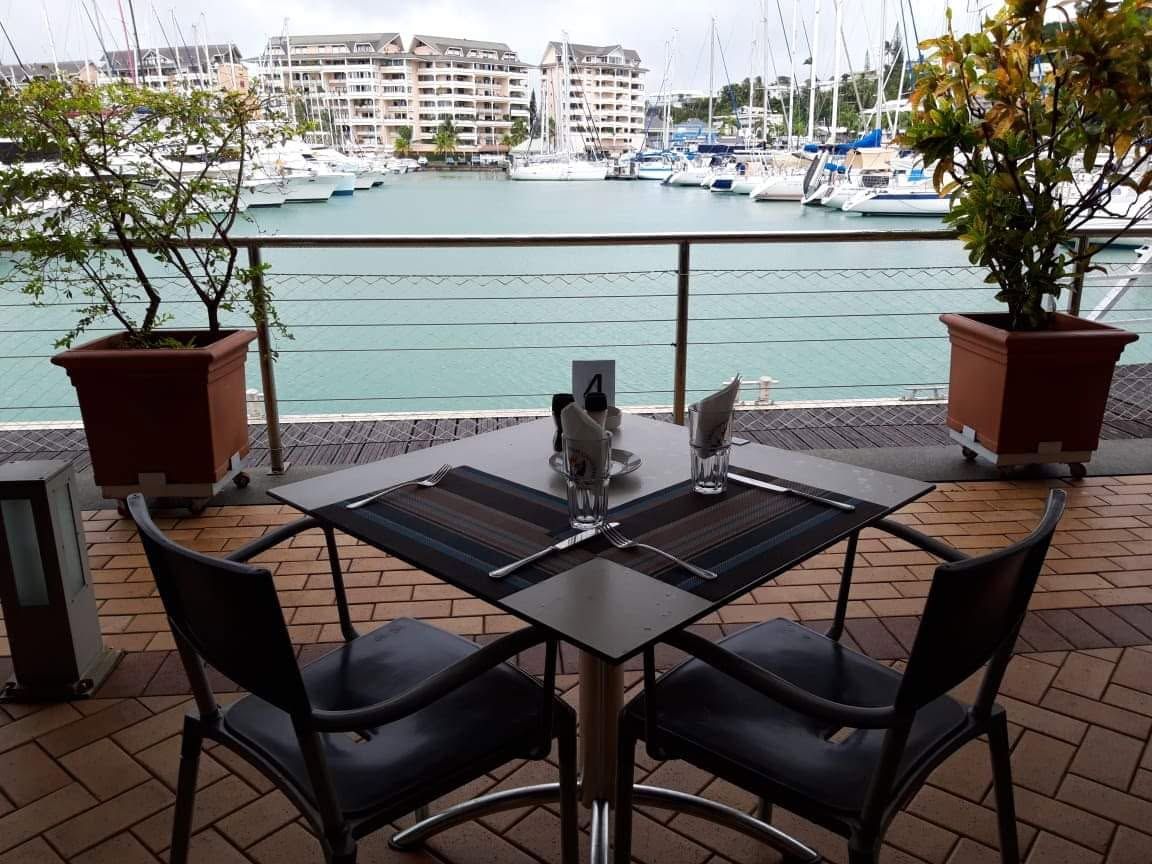 Une table pour deux en terrasse, au bord de la marina
